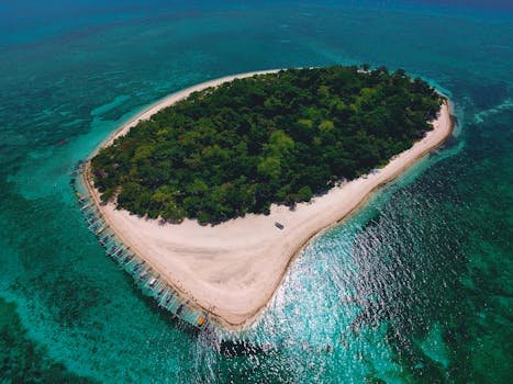 Breathtaking aerial view of a lush tropical island surrounded by azure waters in Northern Mindanao, Philippines.