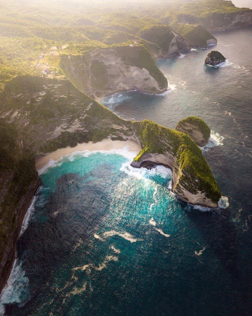 Stunning aerial view of Bali's coastline with turquoise waters and lush cliffs.