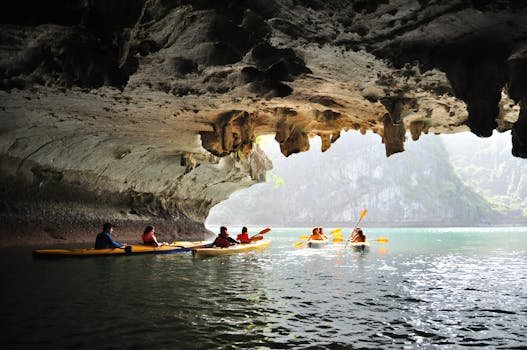 Adventure seekers kayaking inside a scenic cave with stunning rock formations and sunlight streaming in.